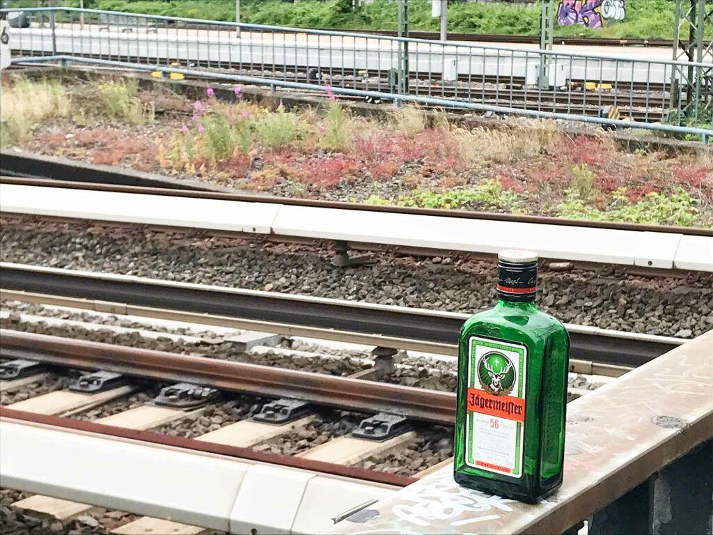 Die leere Flasche Jägermeister auf der Brüstung